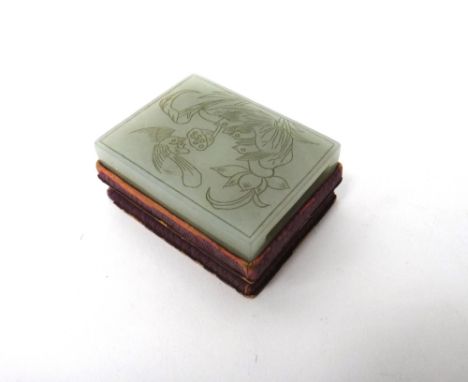 A Chinese pale celadon jade belt slide, 19th century, carved in low relief with several chicks nesting within a lotus leaf, t