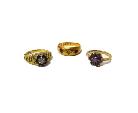 An 18ct gold, ruby and diamond set three stone gypsy ring, Chester 1916, a 9ct gold and amethyst set seven stone cluster ring