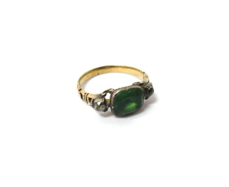 A green and colourless paste set ring, mounted with the foil backed green paste at the centre, between two smaller foil backe