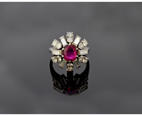 A ruby and diamond set cluster ring, claw set with the oval cut ruby at the centre, in a diamond set surround, mounted with s