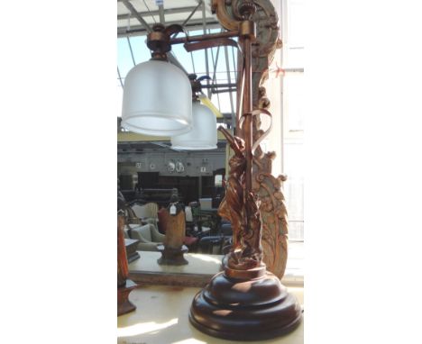 A patinated spelter figural table lamp of Art Nouveau style modelled and cast as a maiden beneath a hanging frosted shade on 