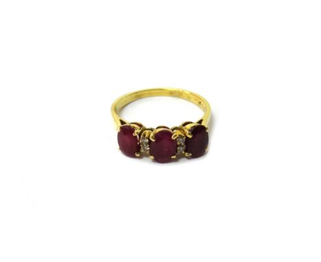 A gold, ruby and diamond set ring, claw set with three oval cut rubies and with two pairs of small circular cut diamonds, mou