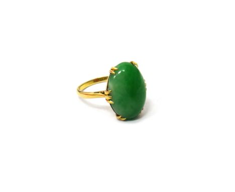 A gold ring, claw set with an oval cabochon jade, detailed 18 CT, ring size K.