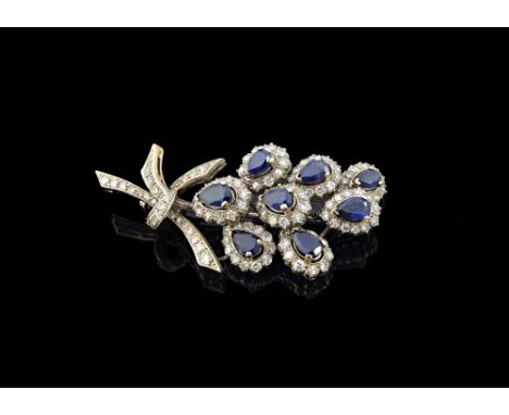 A diamond and sapphire set brooch, designed as a spray, mounted with eight pear shaped sapphires, each with a surround of cir