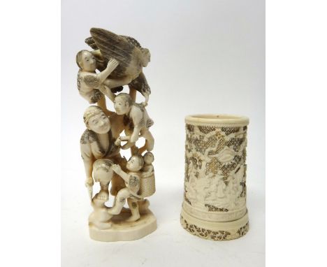 A Japanese ivory okimono, Meiji period, carved as a man carrying an axe and surrounded by five children and a bird, 20cm. hig