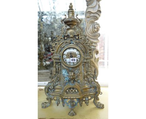 A brass clock garniture, late 20th century, with two handled urn surmount over a pierced foliate cast body flanked by a pair 