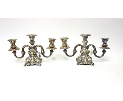 A pair of Danish three light table candelabra, each with scrolling arms and on a shaped square base, loaded, 18cm high. 