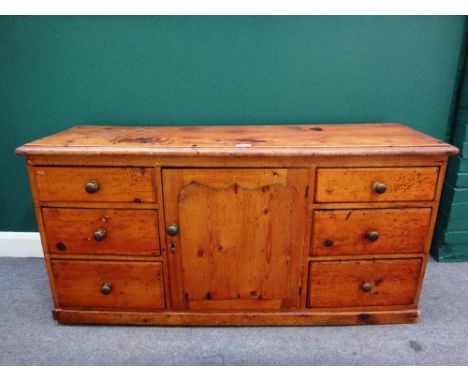 A 19th century pine dresser base, the central panel cupboard flanked by three graduated drawers to each side, 152cm wide.