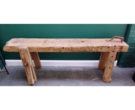 An oak framed rectangular work bench, with integral leg vice and moveable wrought iron bracket, 189cm wide.