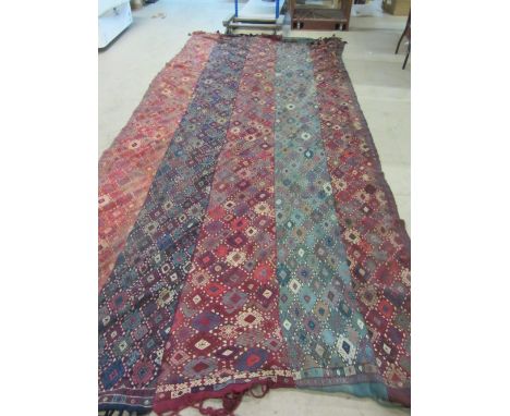 A Turkman flatweave carpet in fine strips, all with embroidered diamond design, 430cm x 182cm.