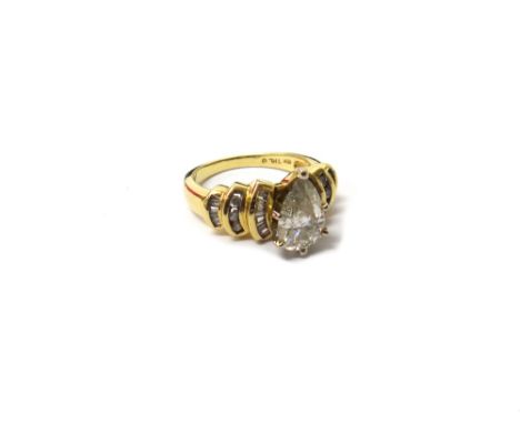 A gold and diamond set ring, claw set with the principal pear shaped diamond at the centre, between diamond set curved steppe