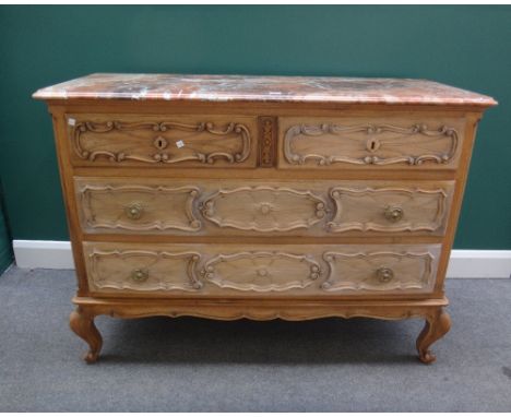 An early 20th century Continental commode, the marble top over a carved bleached oak base with two short and two long drawers