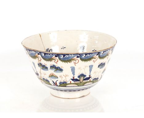 A rare Bristol Delftware polychrome punch bowl, circa 1730, the exterior decorated with four groups of cottages with smoking 