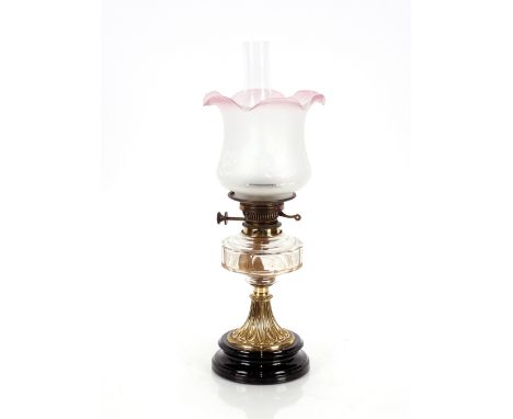A Victorian oil lamp,&nbsp;having brass column, clear glass reservoir and tinted shade, 57cm high overall&nbsp;