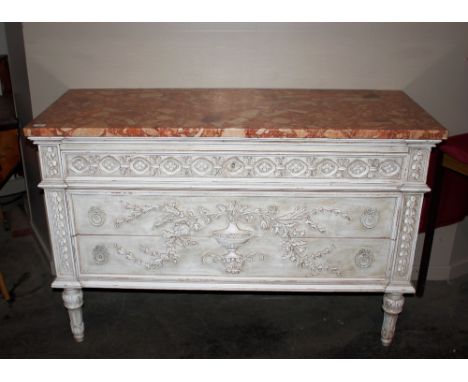 A French cream pained commode,&nbsp;surmounted by a marble top, having blind frieze drawer with two drawers below, profuse ap