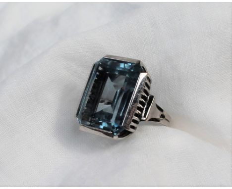 A topaz dress ring, the rectangular faceted light blue topaz, approximately 20mm x 15mm to a white metal setting and shank