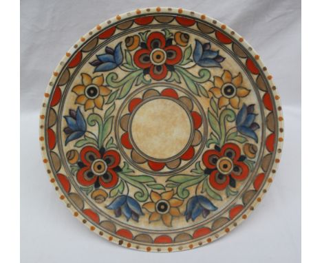 A Crown Ducal, Charlotte Rhead pottery charger decorated with orange, blue and yellow flowers to a mottled orange ground, pri