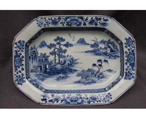 A Chinese blue and white porcelain meat plate, of octagonal form, decorated with a river scene with pagodas and a mountain ra