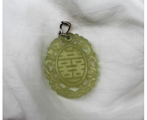 A light green jade panel, of oval form, pierced, with dragon carving and line decoration, 47mm x 35mm