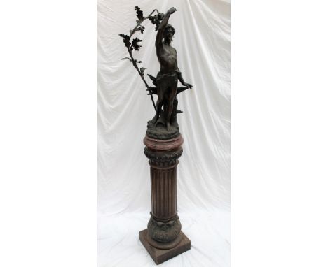 A large spelter lamp depicting a male figure in front of an anvil, with an oak tree at his back with acorns, fitted with ligh