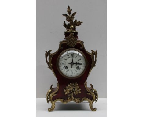 A French tortoiseshell and gilt metal mantle clock, with a scroll and leaf cresting, with C scroll decoration, on scrolling f