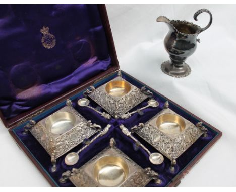 A set of four silver table salts of square form, embossed with leaves on claw feet, with matching feet, London, 1974, cased t