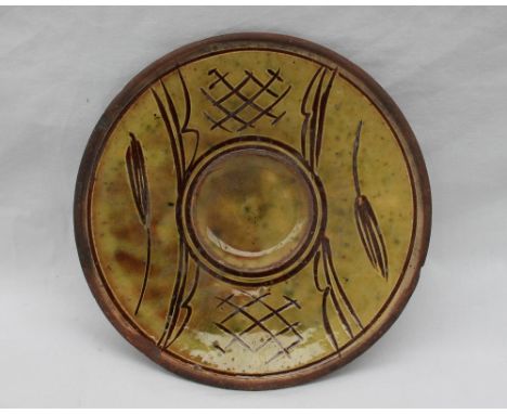 A Michael Cardew Winchcombe pottery saucer dish, decorated with a mustard yellow glaze and decorated with flower heads, impre
