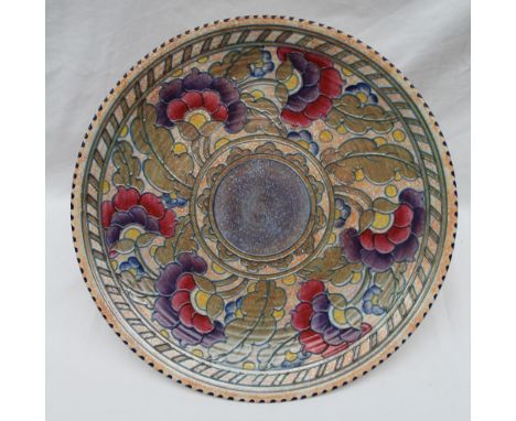 A Crown Ducal, Charlotte Rhead pottery charger decorated with purple, red and yellow flowers to a mottled orange ground, prin