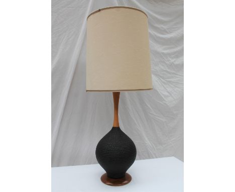 A 20th century turned walnut and textured ribbed black pottery table lamp, on a walnut base, 92cm high 