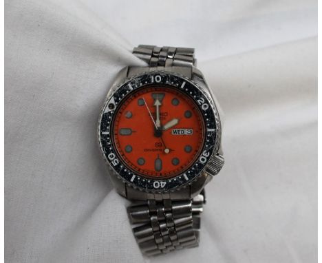 A Gentleman's stainless steel Seiko divers wristwatch, the orange dial with batons and dot markers with day date at 3, inscri