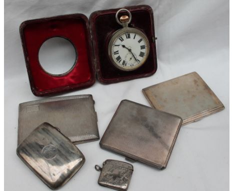 A George V silver and tortoiseshell desk watch case with a Goliath watch, four silver cigarette cases, and a silver vesta cas