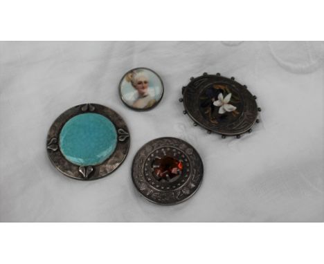 An Arts & Crafts polished pewter brooch with central blue/green Ruskin roundel, diameter 37mm, stamped Plantagenet, hand wrou