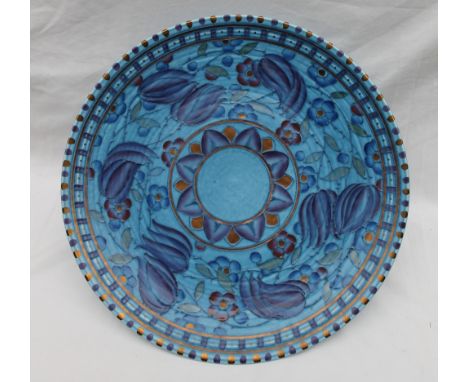 A Crown Ducal, Charlotte Rhead pottery charger decorated with purple, blue and orange flowers to a mottled blue ground, print