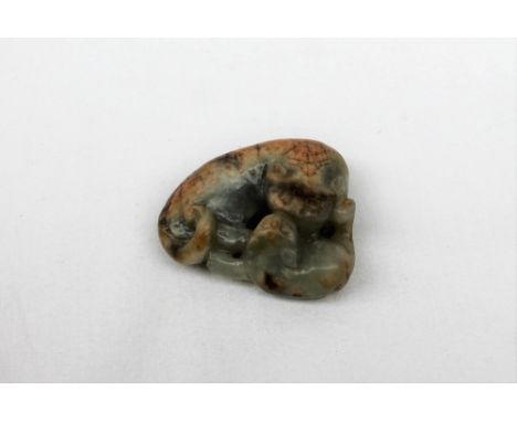A Chinese jade carving of a lion dog recumbent playing with its puppy, 48mm x 42mm