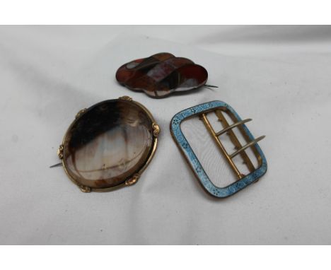 A blue enamel and gilt metal buckle, decorated with flowerheads and leaves together with a moss agate brooch and a hardstone 
