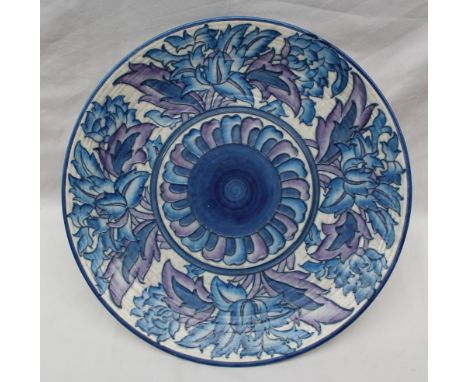 A Crown Ducal, Charlotte Rhead pottery charger decorated with blue and purple flowers to a white ground, printed mark, No.401