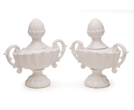 A PAIR OF TWIN HANDLED CERAMIC URNS
Each with scrolling handles and scalloped body, with an acorn shaped finial
38cm x 40cm x