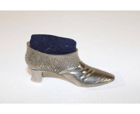 A heavy novelty shoe form pin cushion 