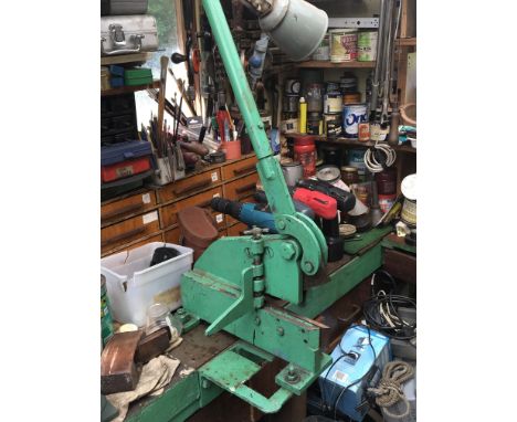 A bench top engineers hand operated metal guillotine
