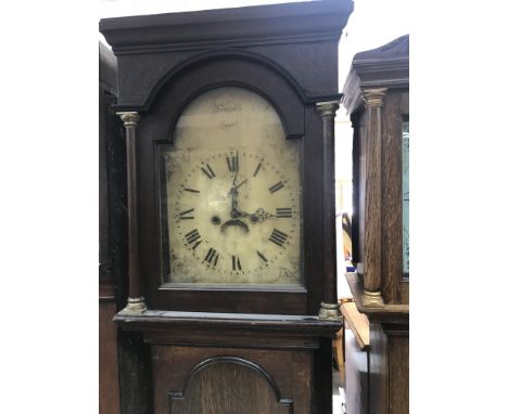 A oak eight day cased long case clock the a the arched dial with Roman numerals.