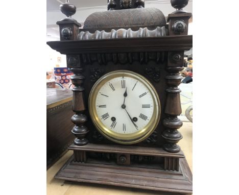 A walnut mantle clock with applied carvings the circular dial with Roman numerals. Together with two other mantle clocks .