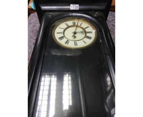 A wall clock the circular dial with Roman numerals with Single weight and visible pendulum.