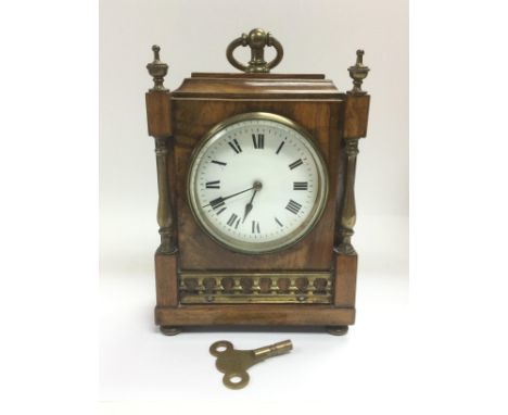A walnut mantle clock with brass fittings, approx height 21cm. Comes supplied with a key. Shipping category D.