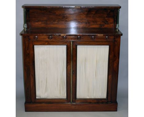 A REGENCY ROSEWOOD CHIFFONIER, with a shelf supported by brass columns, over a pair of glazed doors, supported on a plinth ba