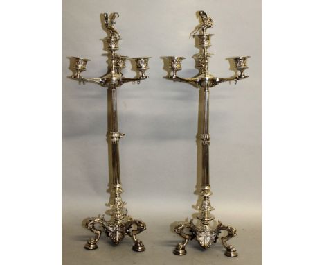 A GOOD PAIR OF PLATED FOUR LIGHT CANDELABRA of classical design, reeded stem on curving legs with claw feet.  23ins high.
