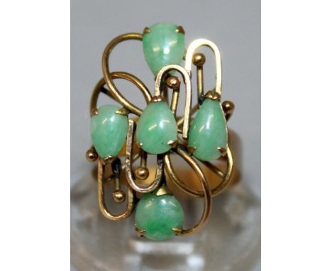 A HIGH GRADE GOLD AND JADE RING set with four jade stones.