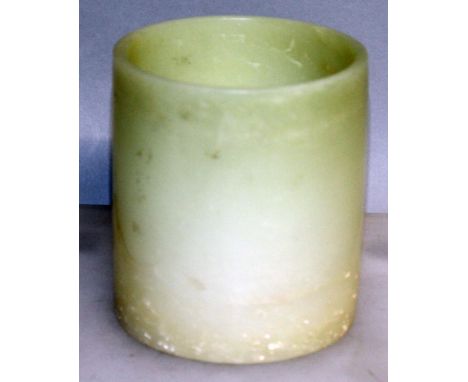 A CHINESE JADE BRUSHPOT, the base with Qianlong seal mark, the pale green stone with lighter inclusions towards the base, 3.7