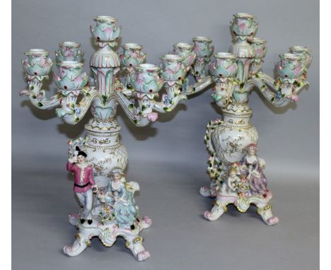 A LARGE PAIR OF "DRESDEN" SEVEN LIGHT CANDELABRA, the base with a man and young lady holding cups of wine. 1ft 8ins high.