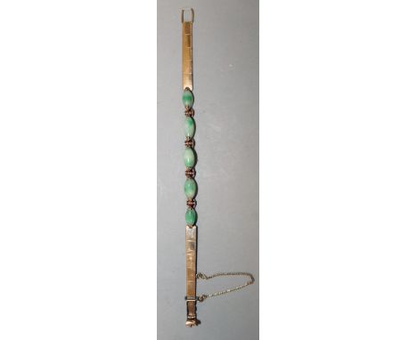 A HIGH GRADE GOLD AND JADE BRACELET set with four oval jade stones.