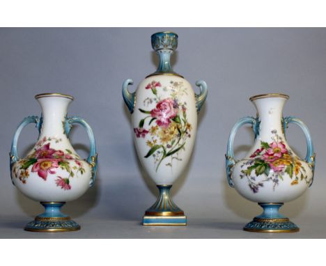 A ROYAL WORCESTER GARNITURE OF THREE VASES painted with flowers having gilt highlights, the neck, handles and socle having a 